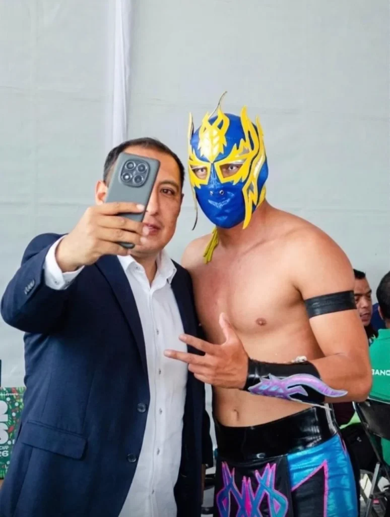 Ejecutivo tomándose selfie con luchador profesional en evento de empresa