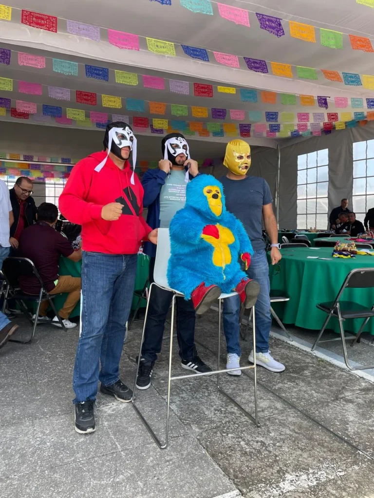 Equipo de empresa conviviendo con luchadores en evento corporativo con mascaras