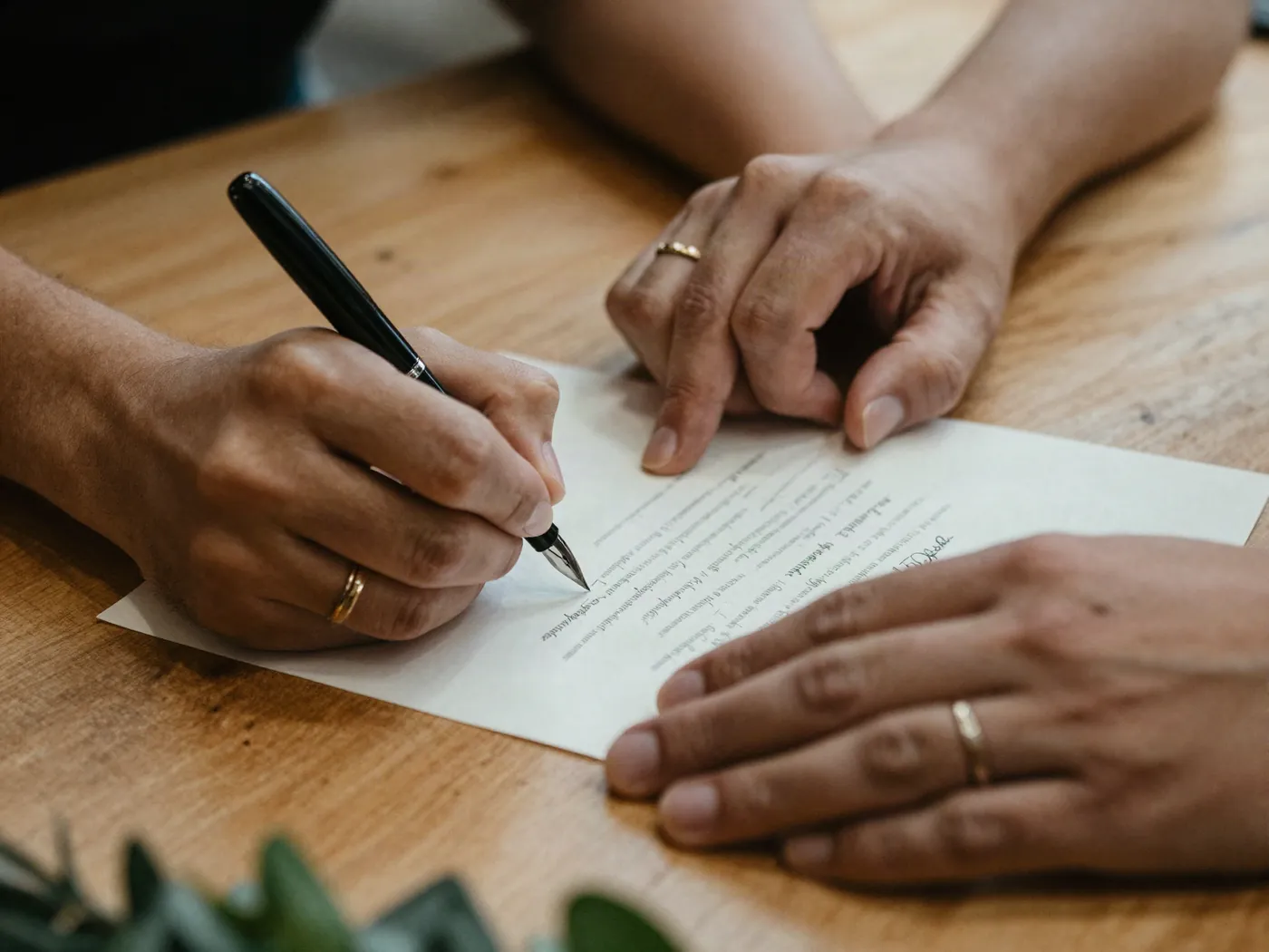 Manos de los novios firmando el acta de matrimonio civil