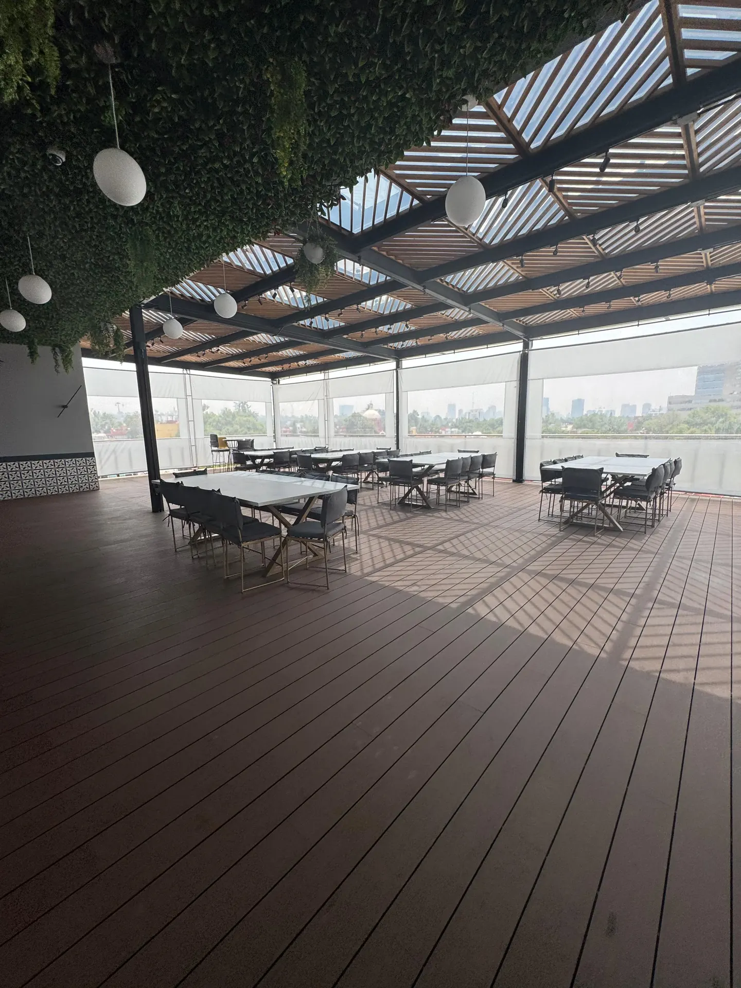 Terraza San Miguel Chapultepec 1 — área de mesas bajo jardín vertical