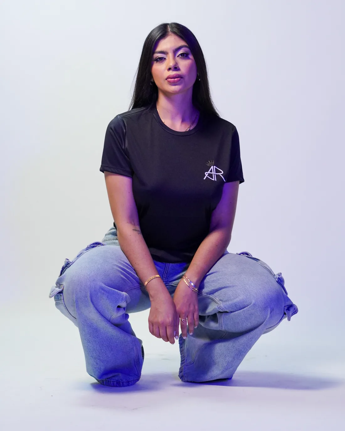 Book de fotos casual con jeans y playera negra en cuclillas