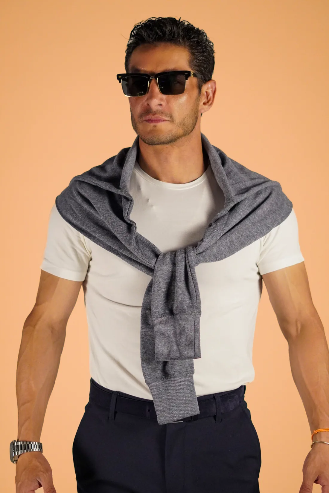 Book de modelaje de hombre con lentes de sol sobre fondo durazno