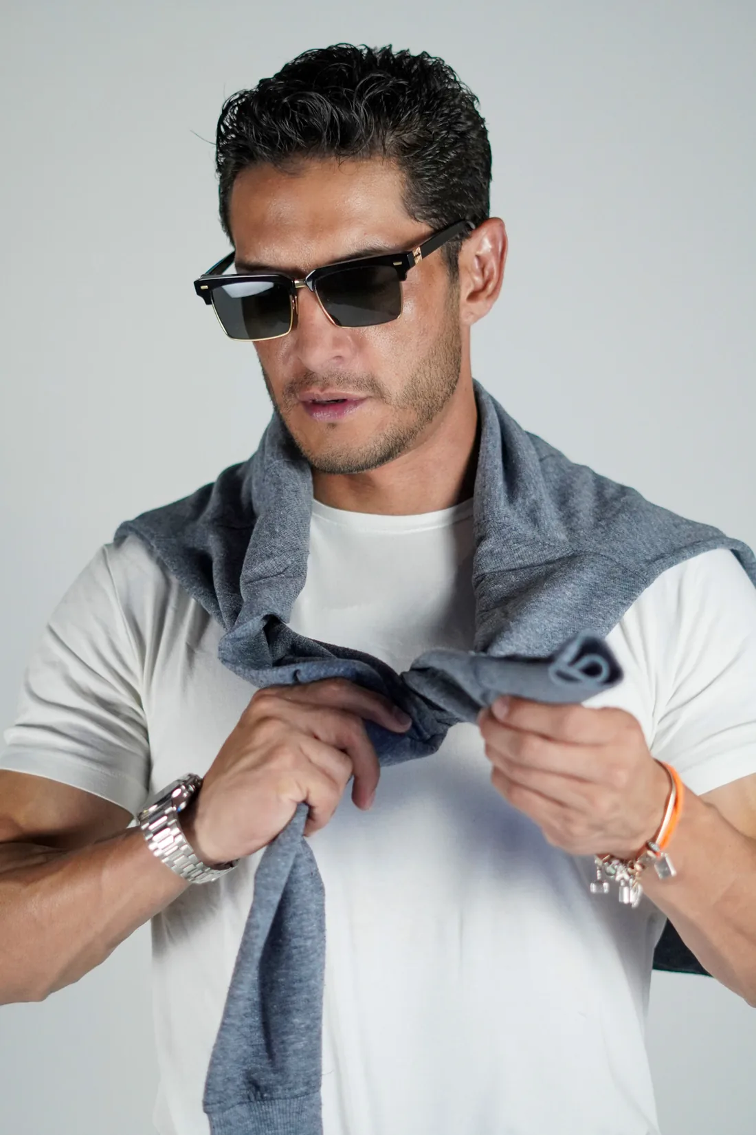 Book de modelaje de hombre con lentes de sol y suéter al hombro