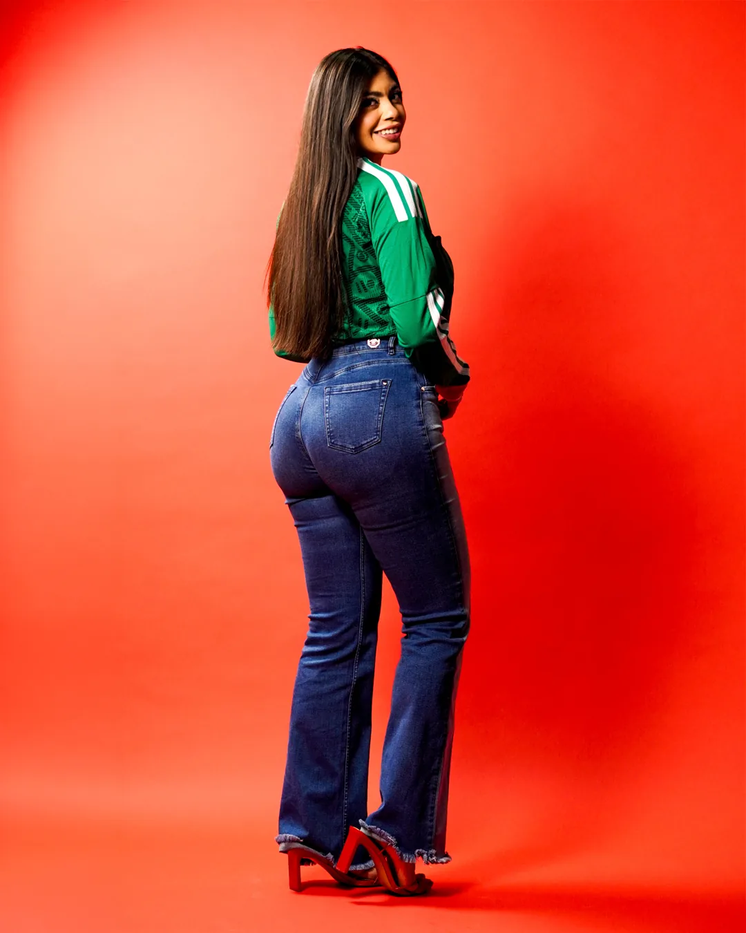 Book de modelaje de cuerpo completo de espalda con jeans y tacones rojos
