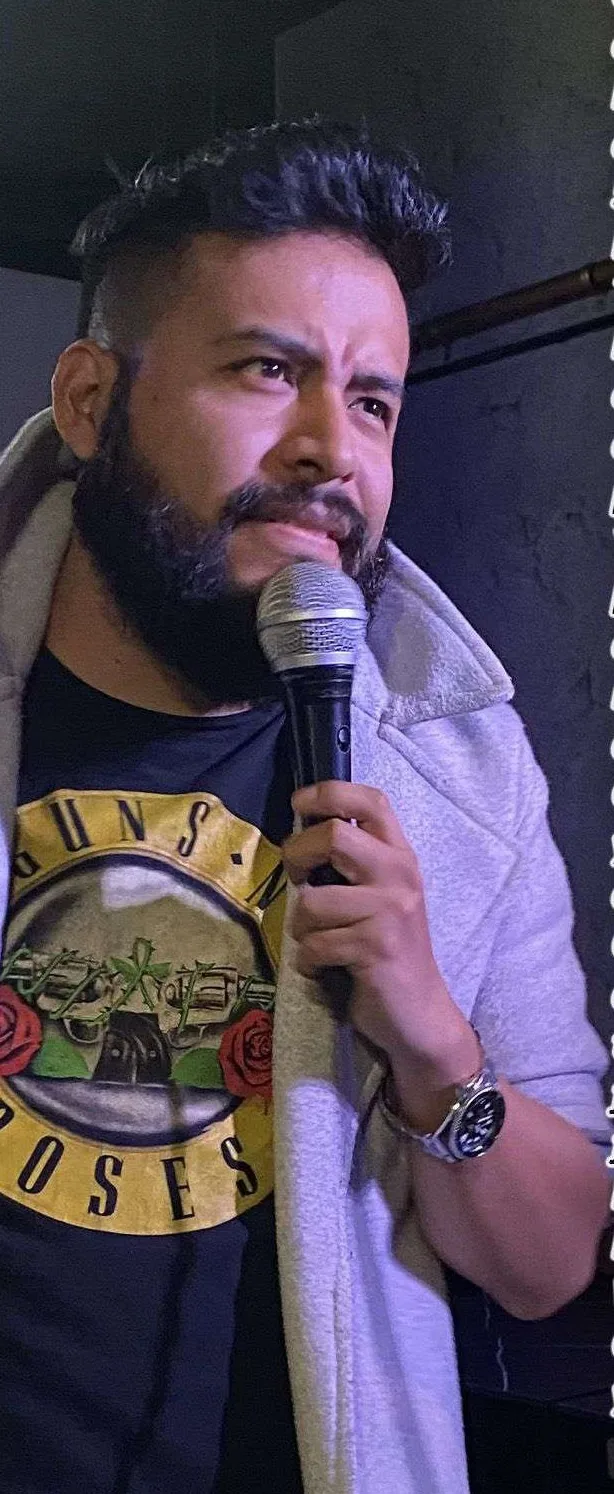 Carlos Mosco en escena con micrófono durante un show de stand up