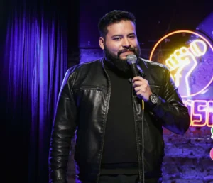 Carlos Mosco, comediante de stand up, con micrófono en un foro de comedia de CDMX