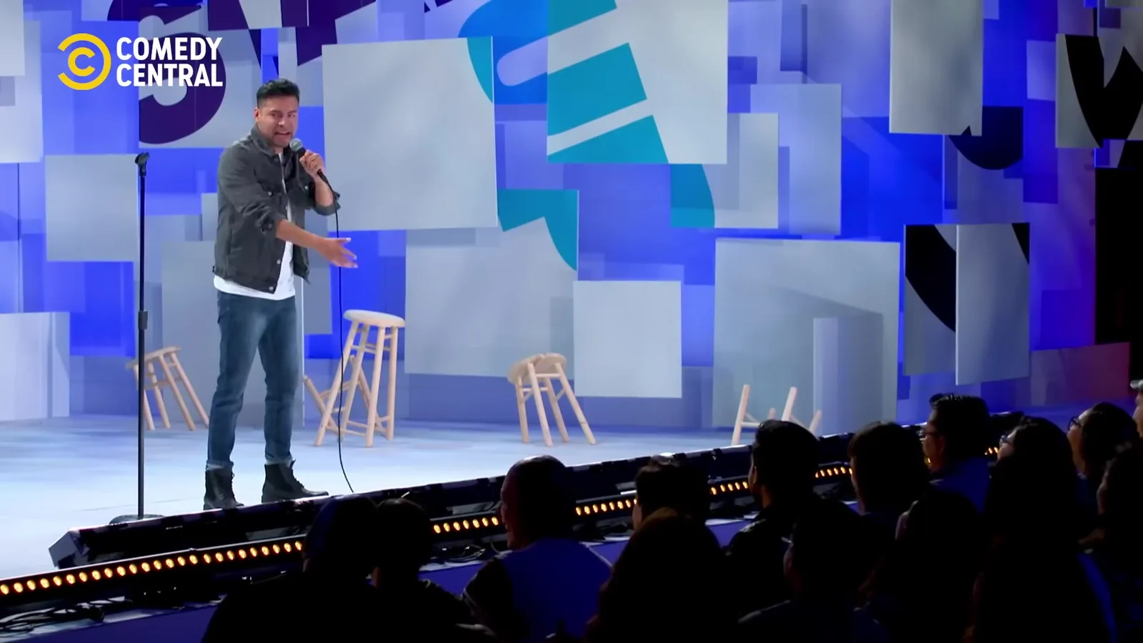 Carlos Mosco con micrófono en el escenario de Stand Up México de Comedy Central