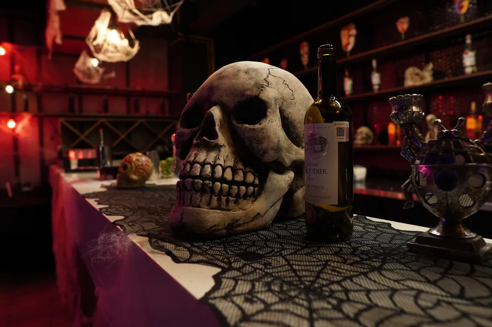 Decoración de Halloween: calavera monumental sobre la barra con telarañas