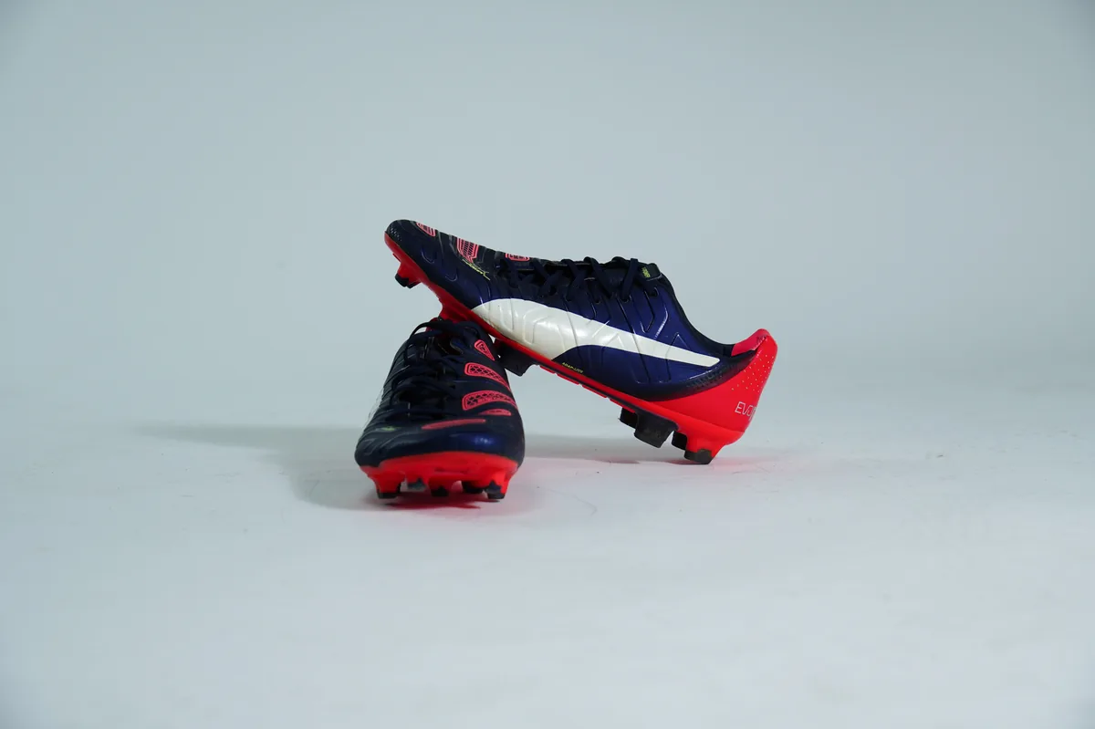 Foto de producto para e-commerce: tacos de futbol azul marino en estudio, toma 34