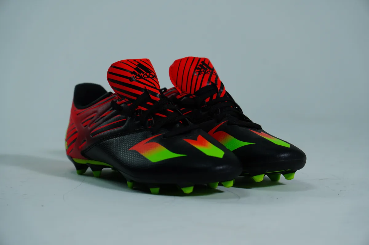 Foto de producto para e-commerce: tacos de futbol negros en estudio, toma 21