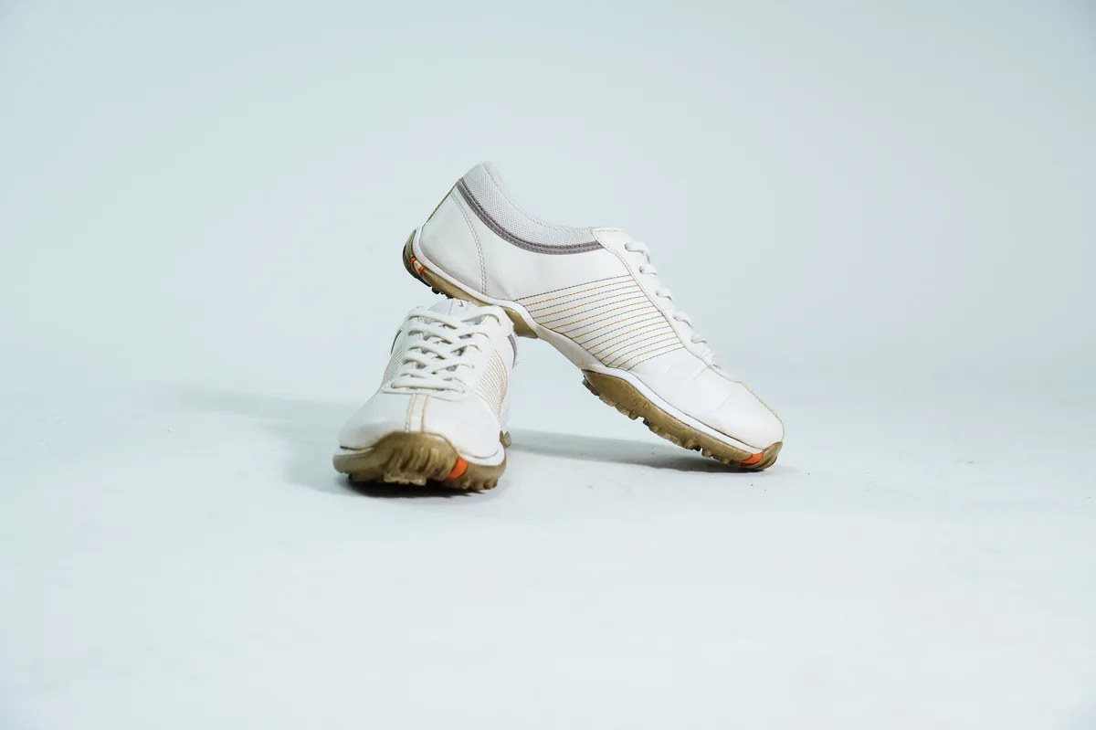 Foto de producto para e-commerce: tenis blancos de piel lisa en estudio, toma 115