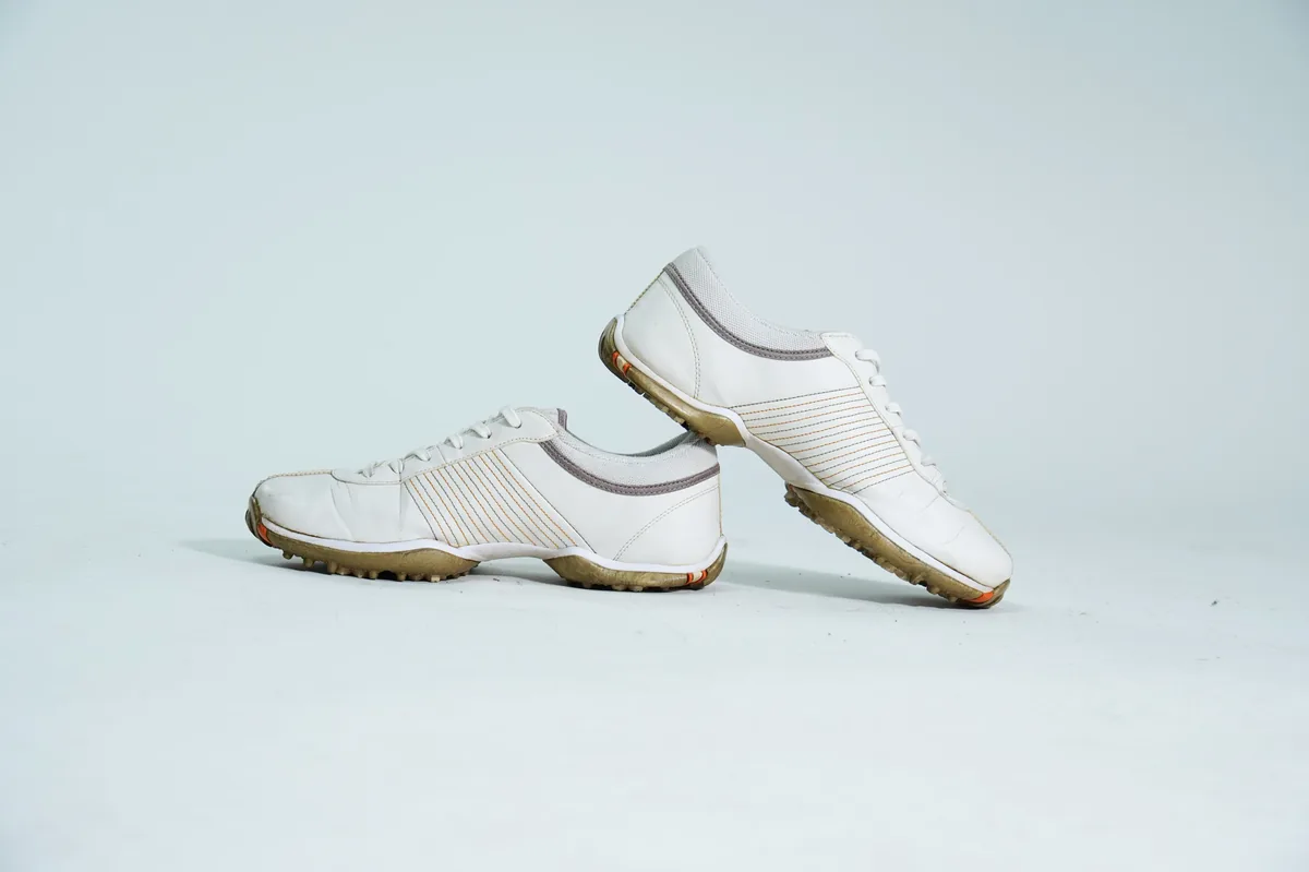 Foto de producto para e-commerce: tenis blancos de piel lisa en estudio, toma 116