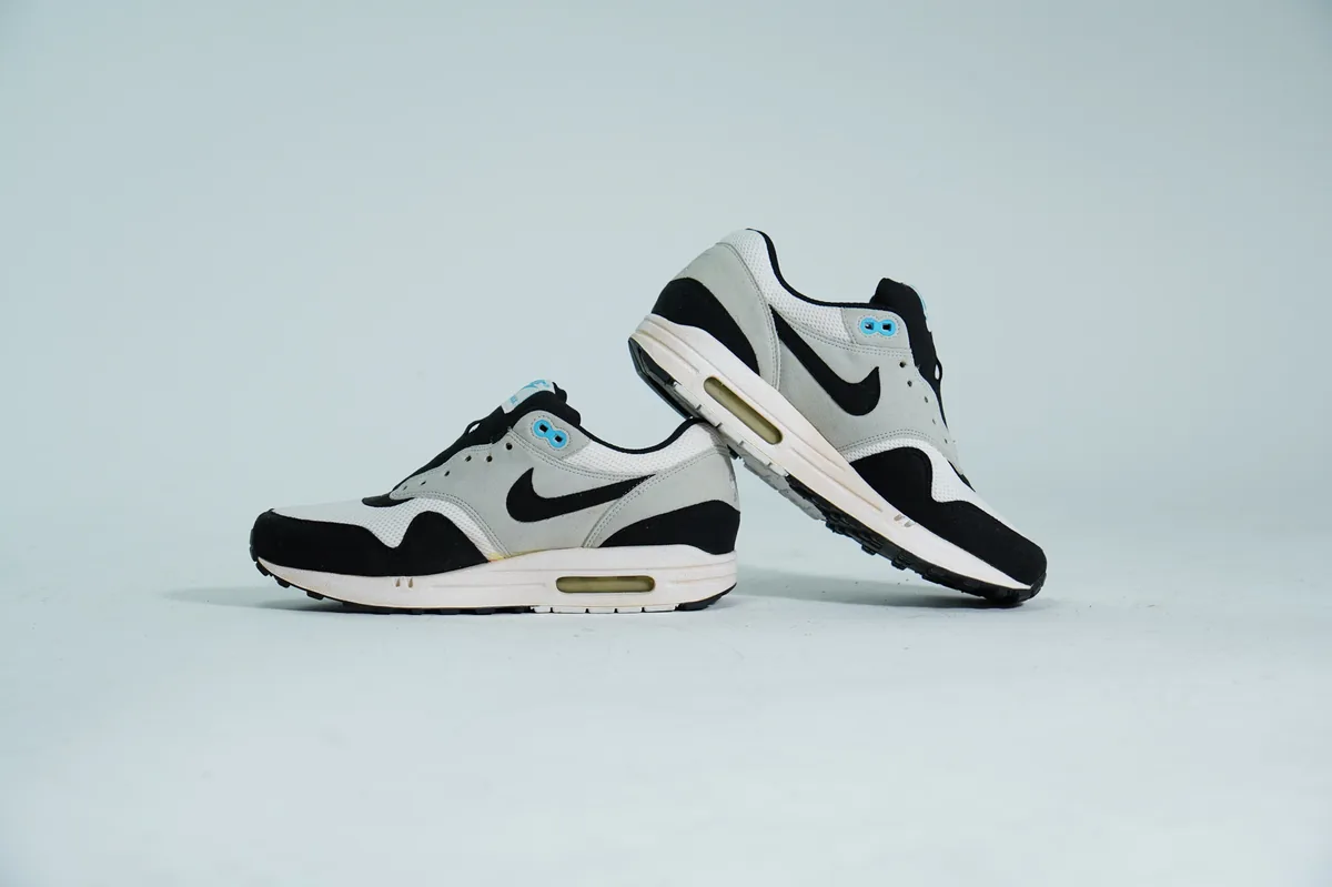 Foto de producto para e-commerce: tenis deportivos blanco con negro en estudio, toma 89