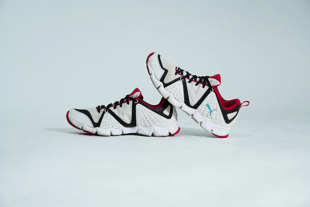 Foto de producto para e-commerce: tenis deportivos blanco con rojo en estudio, toma 101