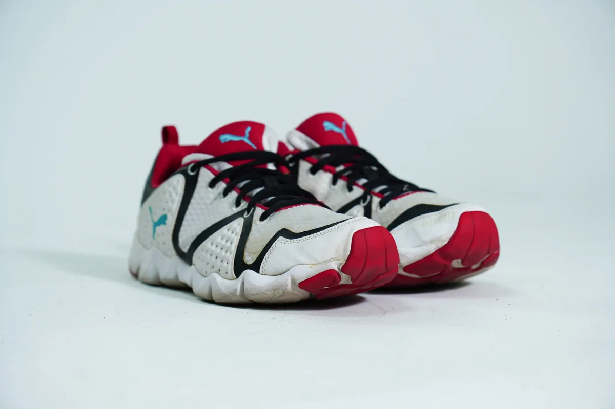Foto de producto para e-commerce: tenis deportivos blanco con rojo en estudio, toma 102