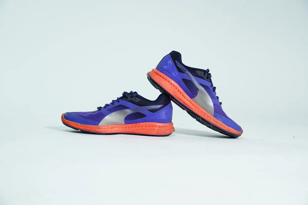 Foto de producto para e-commerce: tenis morados con naranja en estudio, toma 137