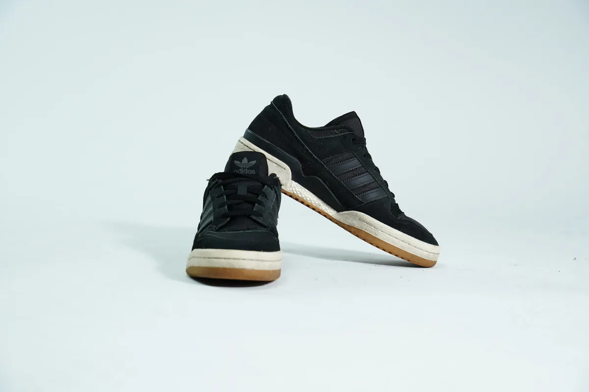 Foto de producto para e-commerce: tenis negros con suela de goma en estudio, toma 121