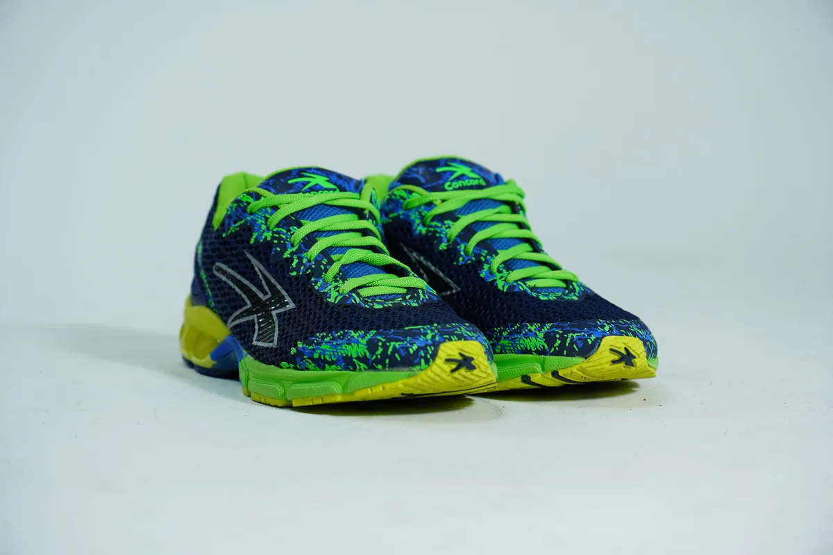 Foto de producto para e-commerce: tenis para correr verde con azul en estudio, toma 111