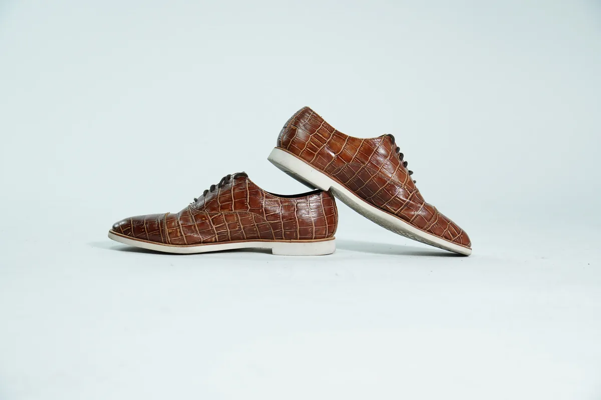 Foto de producto para e-commerce: zapatos de vestir cafés tipo oxford en estudio, toma 140