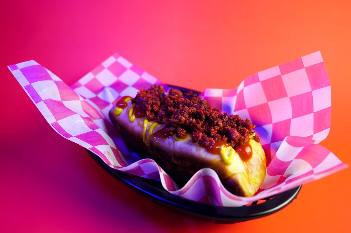 Fotografía de alimentos en estudio: hot dog con chorizo sobre fondo de color, toma 15