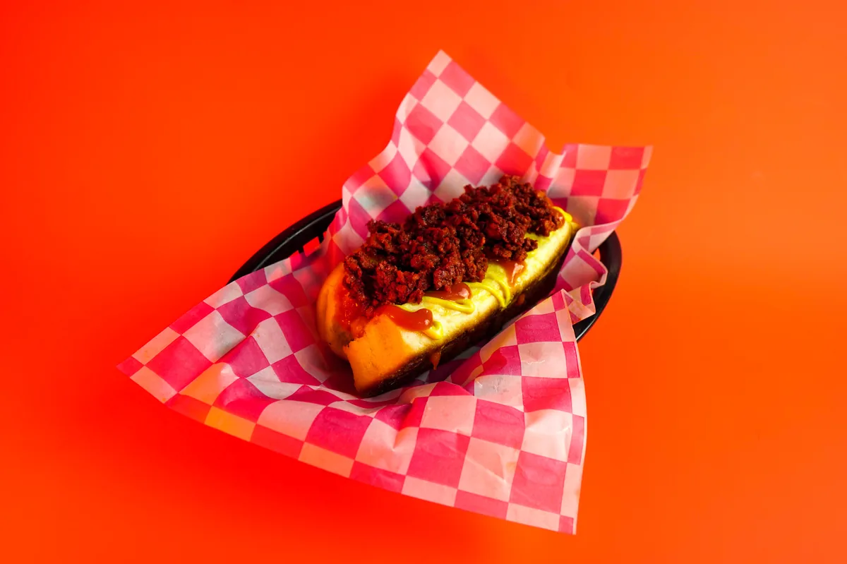 Fotografía de alimentos en estudio: hot dog con chorizo sobre fondo de color, toma 16