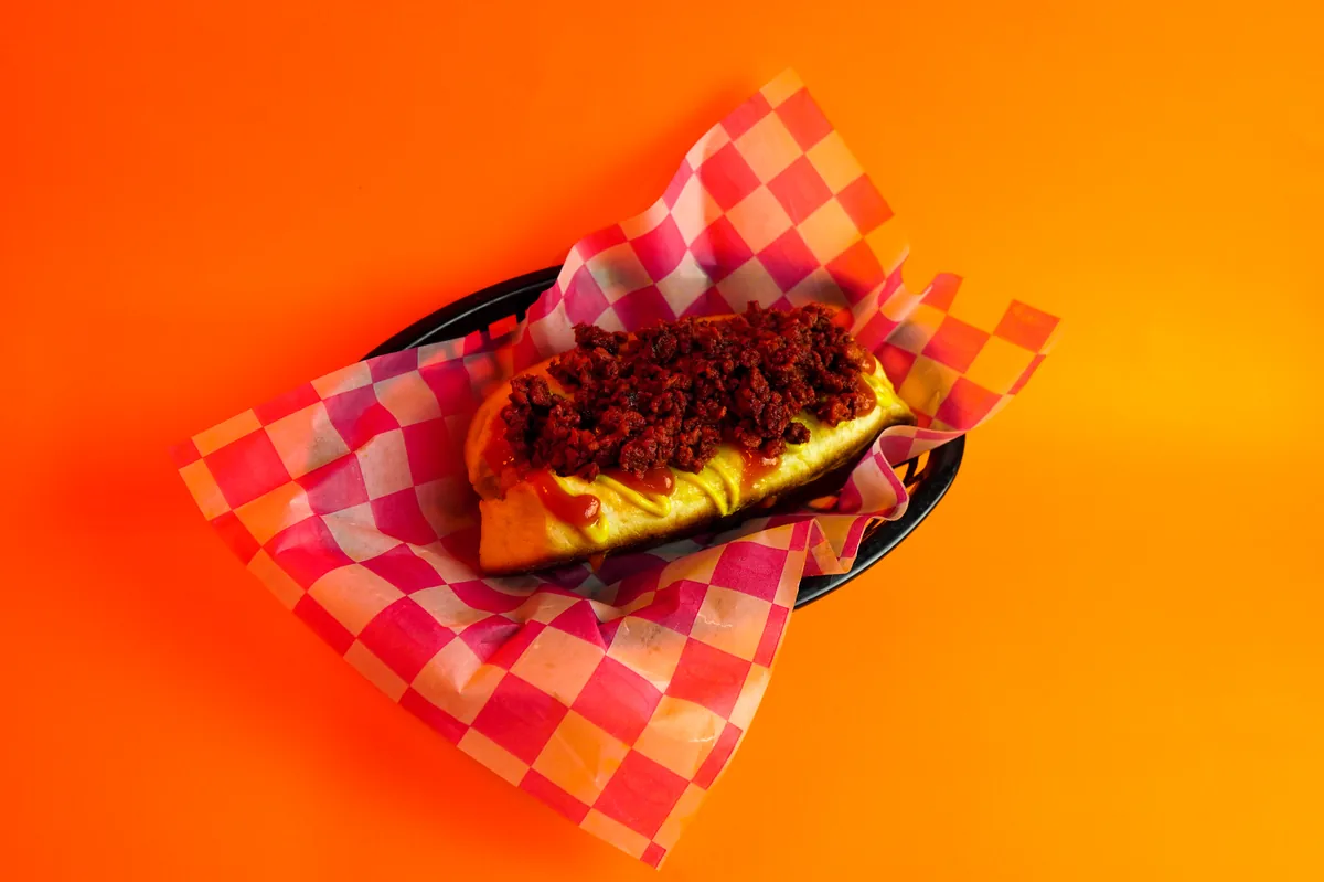 Fotografía de alimentos en estudio: hot dog con chorizo sobre fondo de color, toma 17