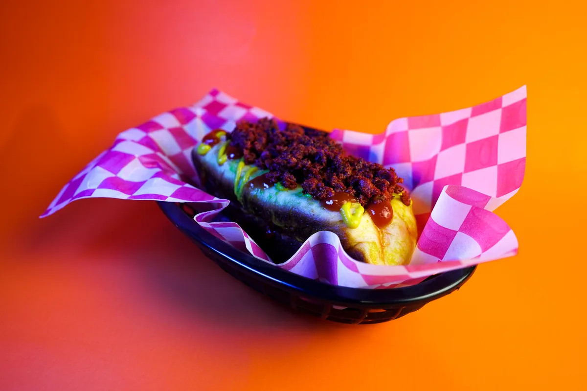Fotografía de alimentos en estudio: hot dog con chorizo sobre fondo de color, toma 18