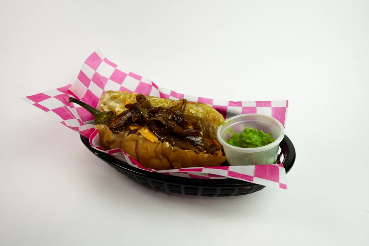 Fotografía de alimentos en estudio: hot dog con guacamole sobre fondo blanco, toma 48