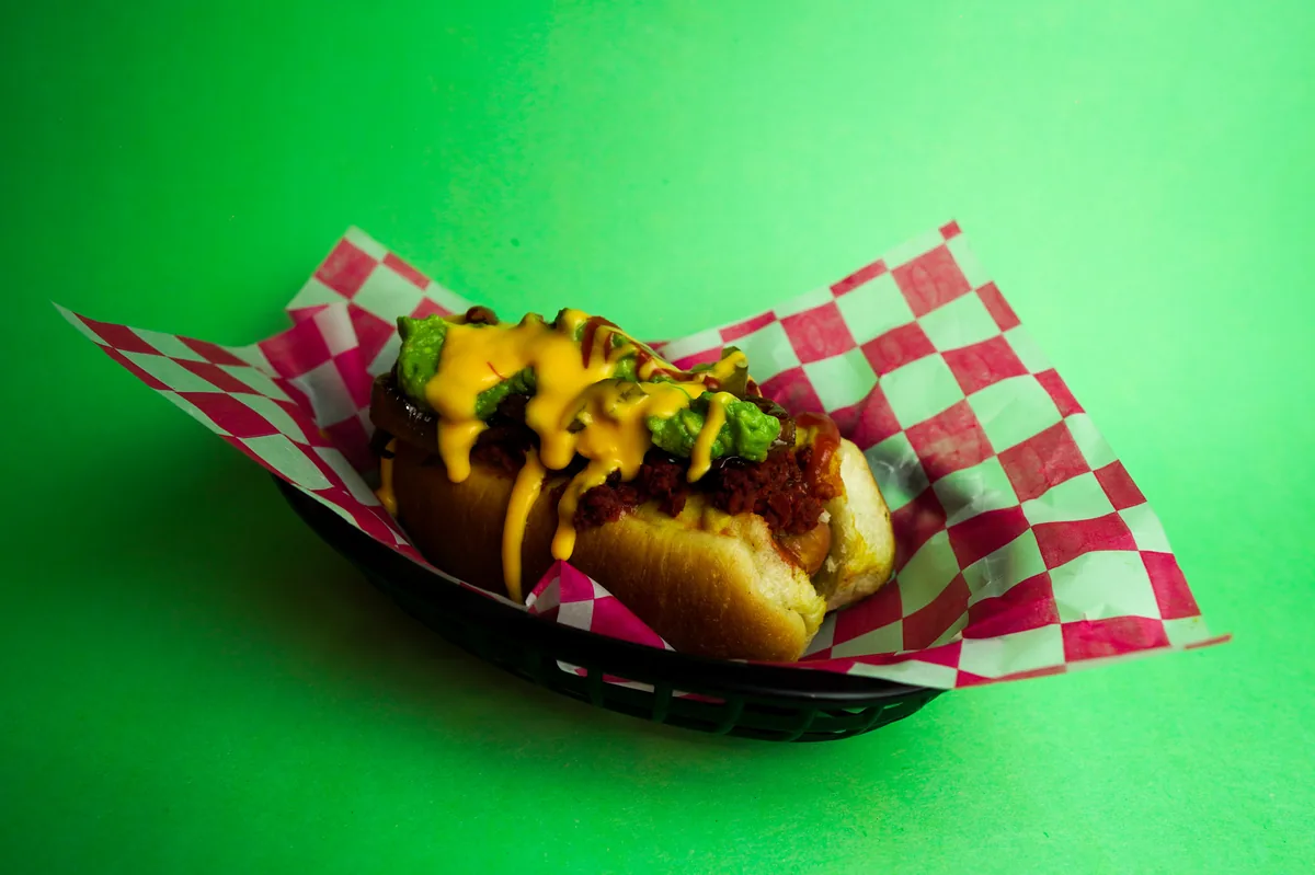 Fotografía de alimentos en estudio: hot dog con queso sobre fondo verde, toma 33
