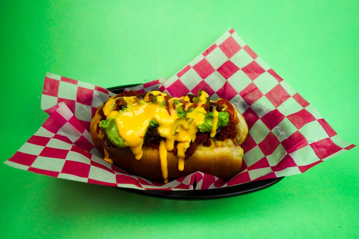 Fotografía de alimentos en estudio: hot dog con queso sobre fondo verde, toma 34