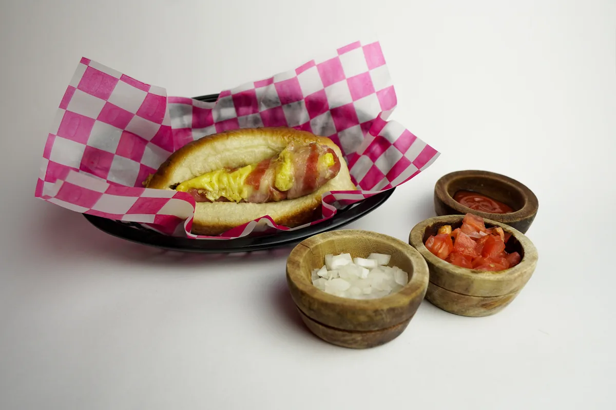 Fotografía de alimentos en estudio: hot dog con salsas sobre fondo blanco, toma 24