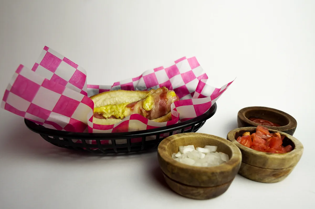 Fotografía de alimentos en estudio: hot dog con salsas sobre fondo blanco, toma 26