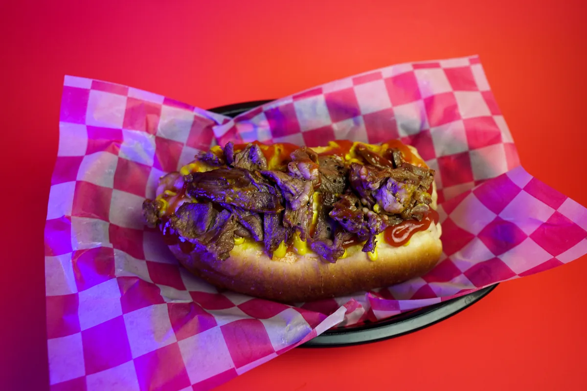Fotografía de alimentos en estudio: hot dog de arrachera sobre fondo de color, toma 3