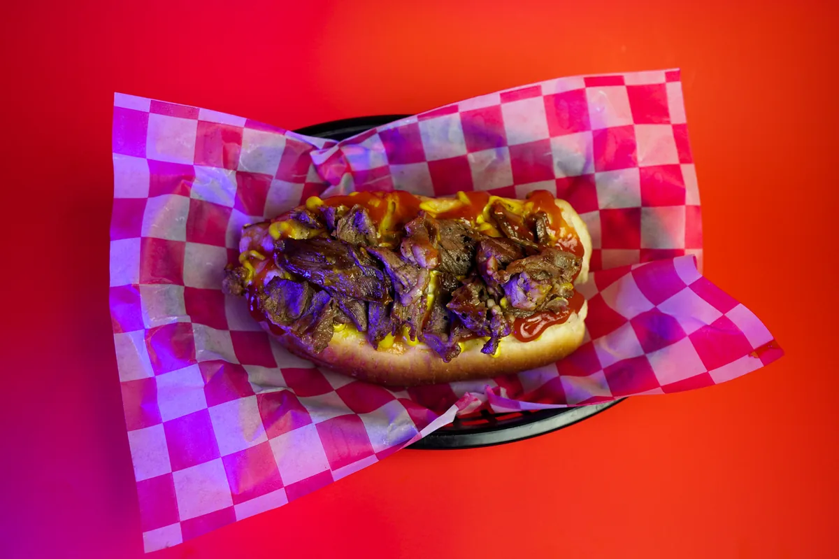Fotografía de alimentos en estudio: hot dog de arrachera sobre fondo de color, toma 4