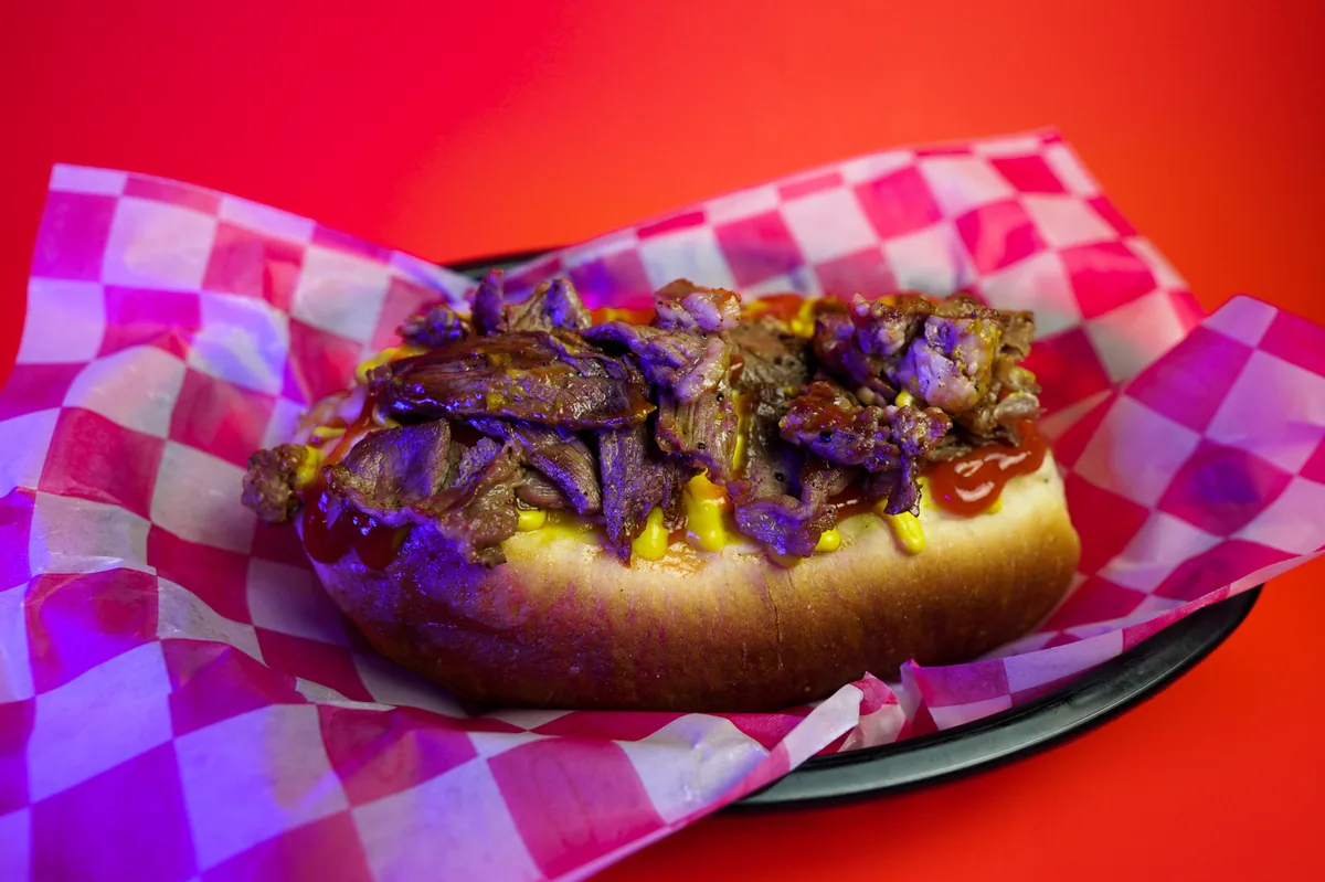 Fotografía de alimentos en estudio: hot dog de arrachera sobre fondo de color, toma 5