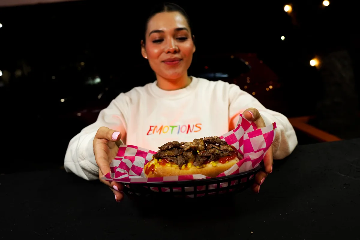 Fotografía de alimentos en estudio: modelo sosteniendo un hot dog en estudio, toma 9
