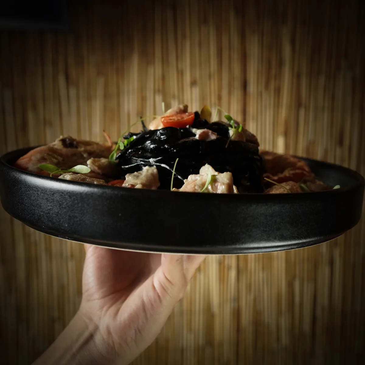 Fotografía gastronómica de restaurante: platillo de mariscos servido en mano, toma 110