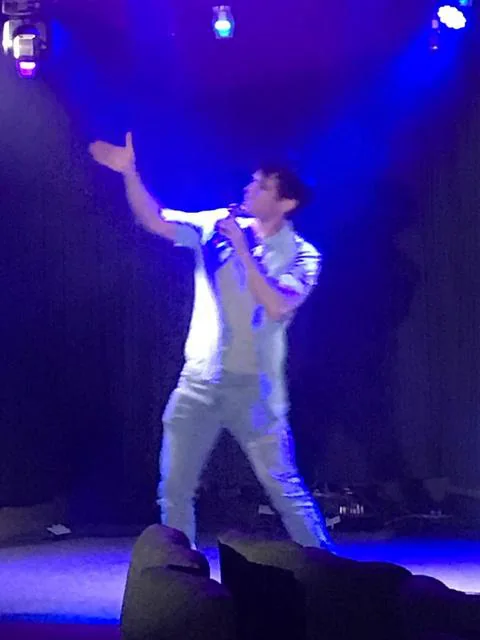 Germán Valdés cantando en vivo en el escenario durante su show