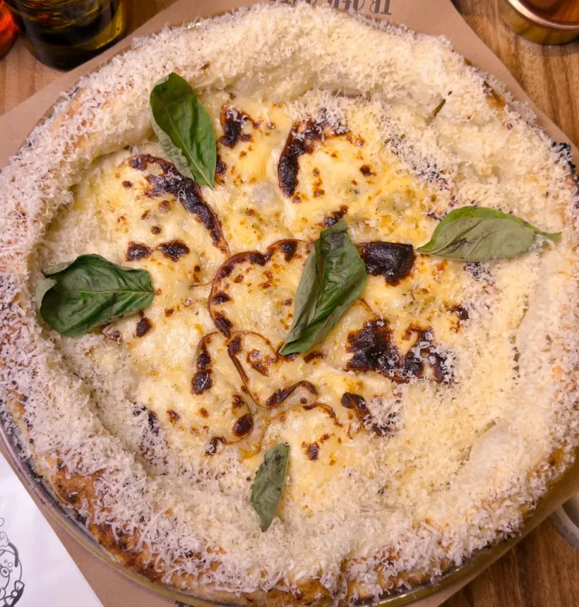 Pizza napolitana de cinco quesos con albahaca