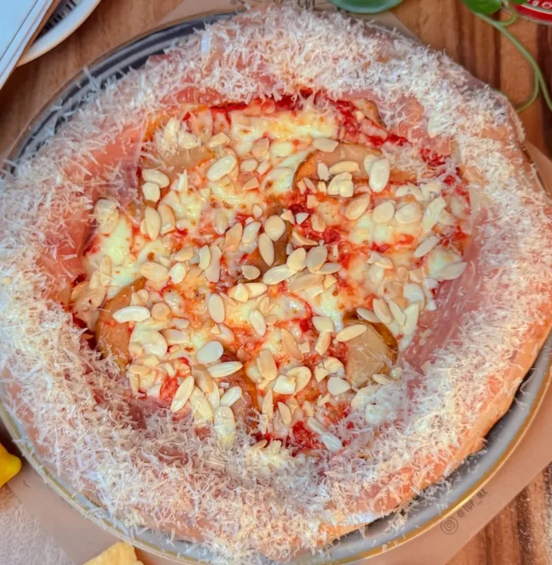 Pizza napolitana de pera, almendra y orilla de jamón serrano