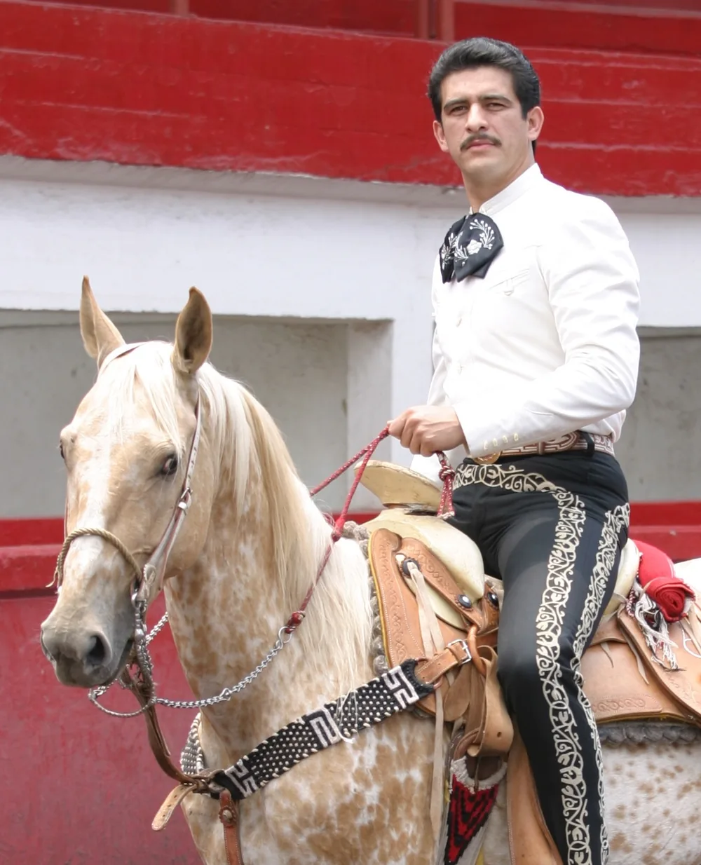 Sergio Albarrán con camisa blanca de charro y su caballo