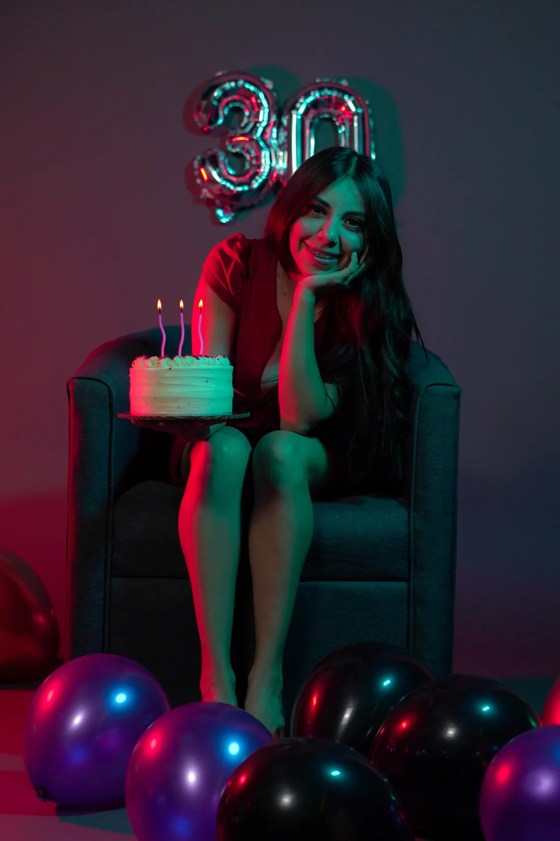 Sesión de fotos de cumpleaños en estudio con pastel y globos en sillón de estudio, toma 50