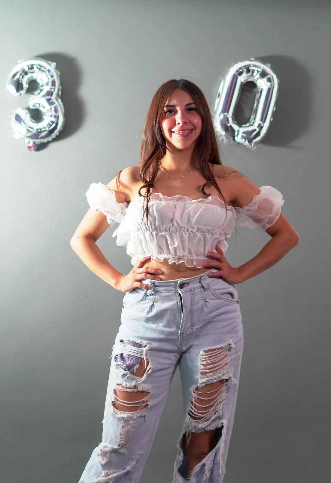 Sesión de fotos de cumpleaños en estudio con top blanco, jeans y globos dorados, toma 66