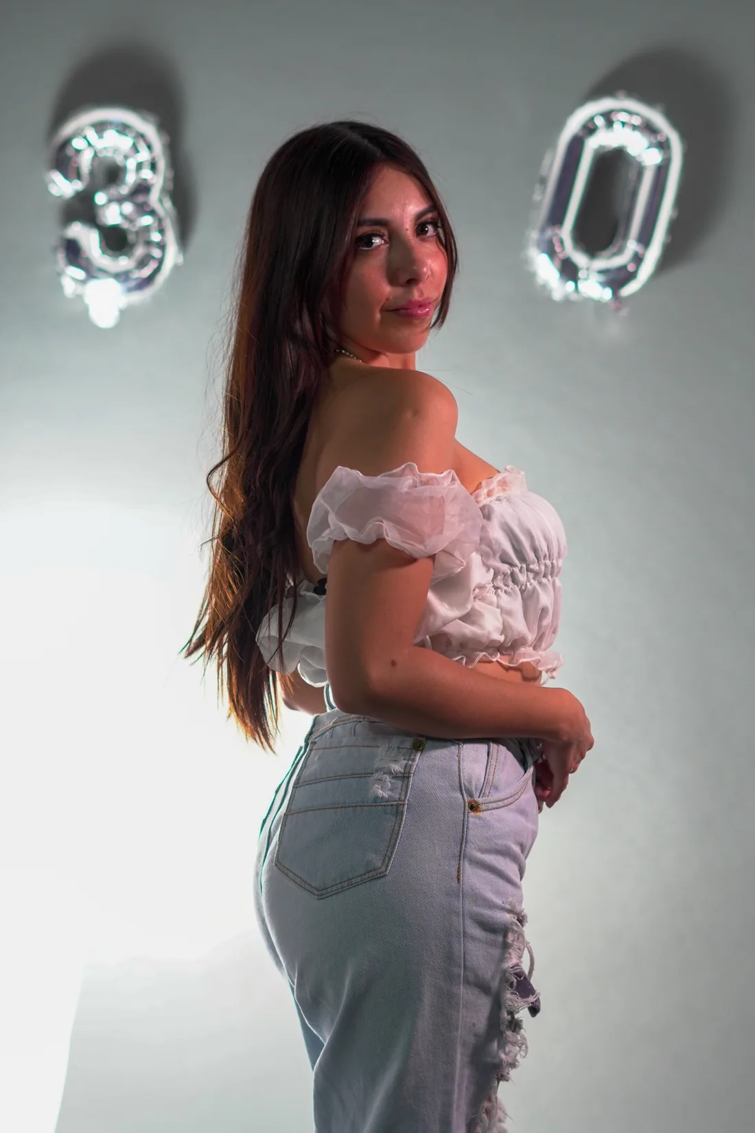 Sesión de fotos de cumpleaños en estudio con top blanco, jeans y globos dorados, toma 67