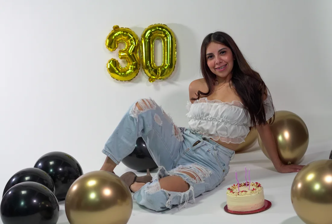 Sesión de fotos de cumpleaños en estudio con top blanco, jeans y globos dorados, toma 69