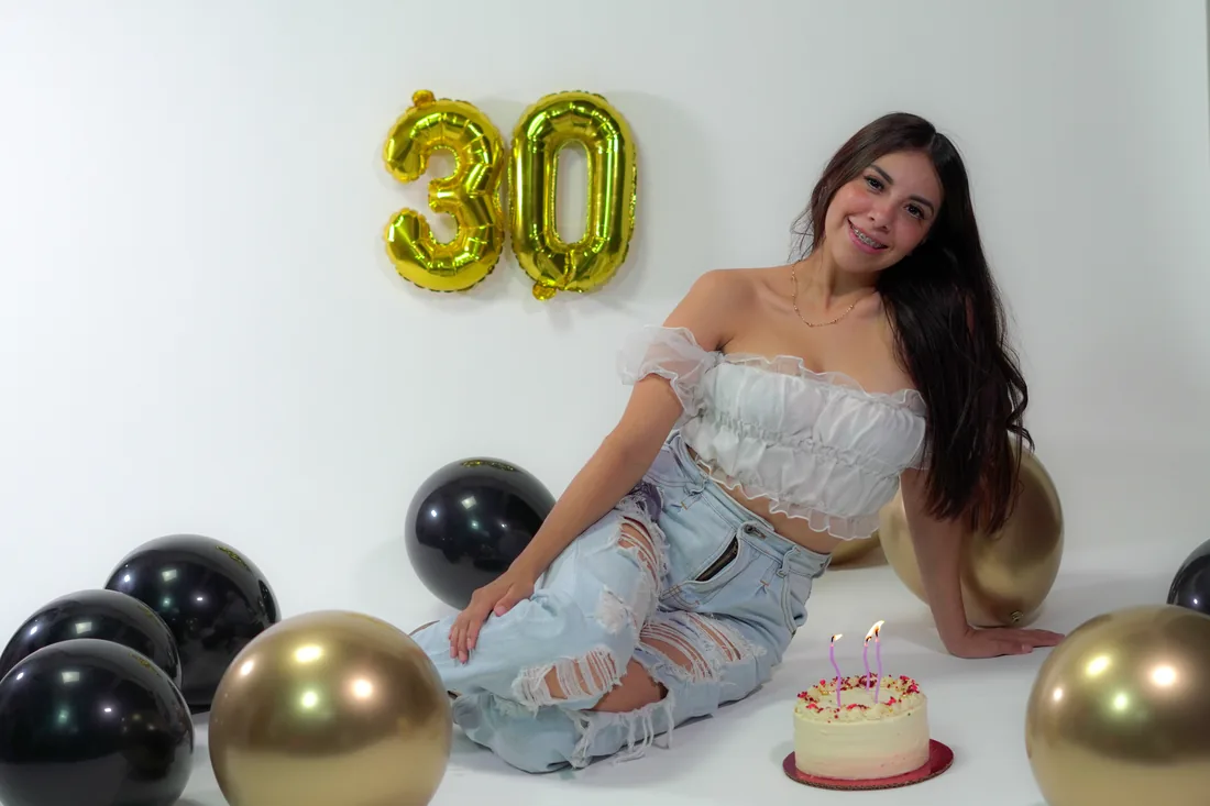 Sesión de fotos de cumpleaños en estudio con top blanco, jeans y globos dorados, toma 70