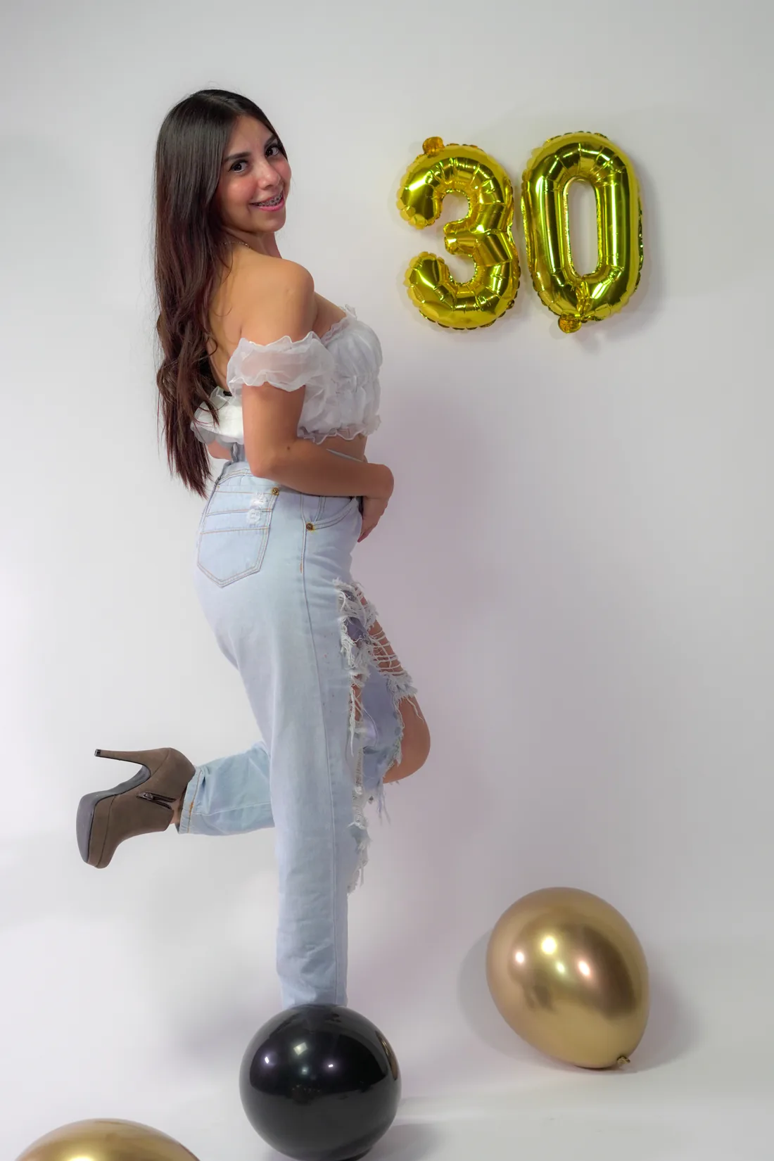 Sesión de fotos de cumpleaños en estudio con top blanco, jeans y globos dorados, toma 74