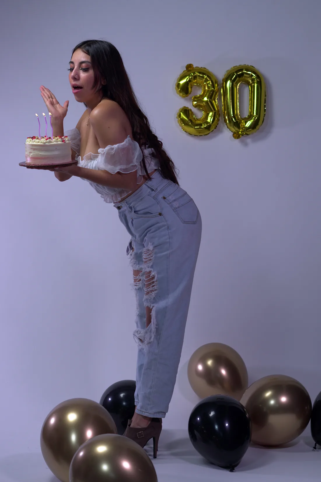 Sesión de fotos de cumpleaños en estudio con top blanco, jeans y globos dorados, toma 78