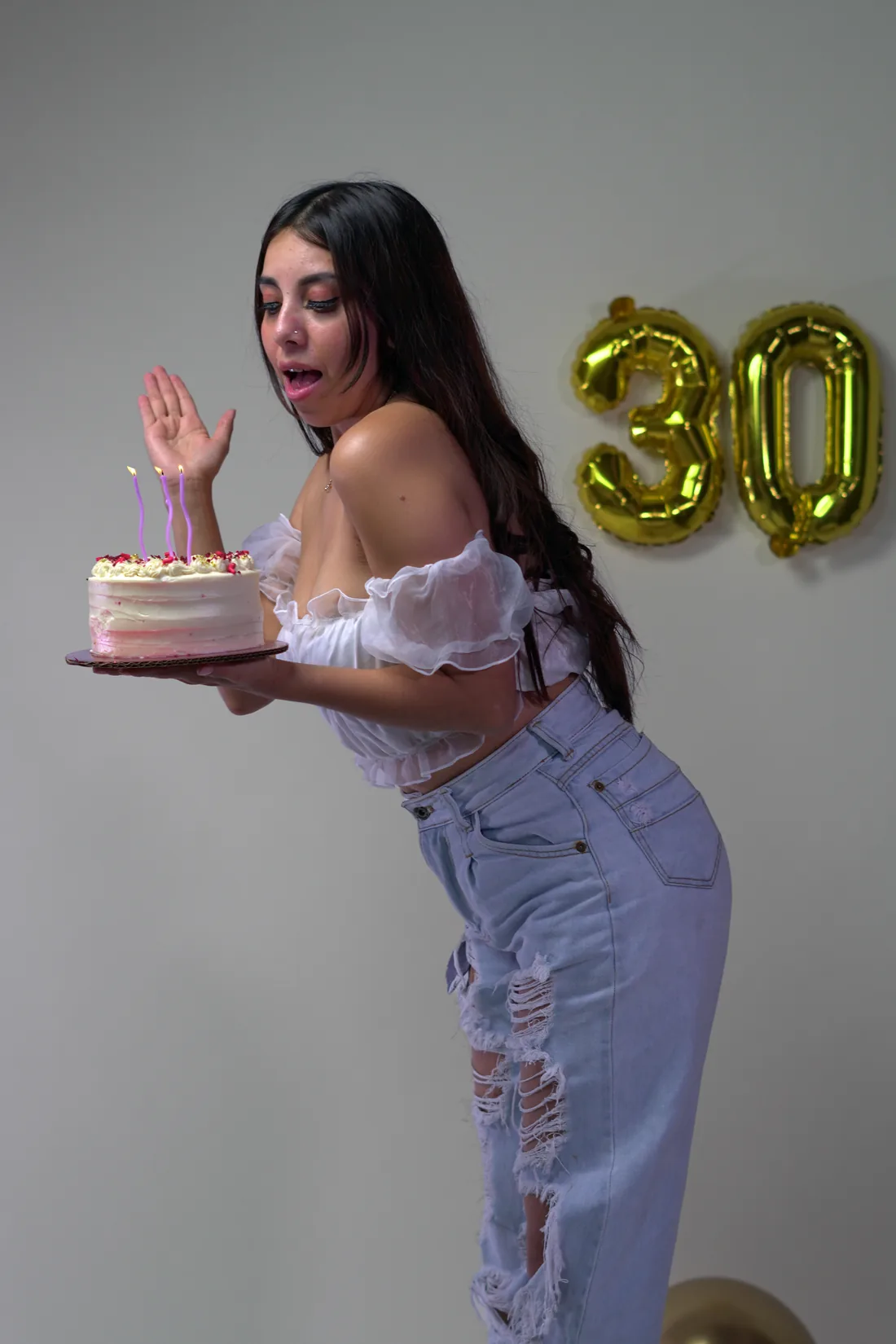 Sesión de fotos de cumpleaños en estudio con top blanco, jeans y globos dorados, toma 79