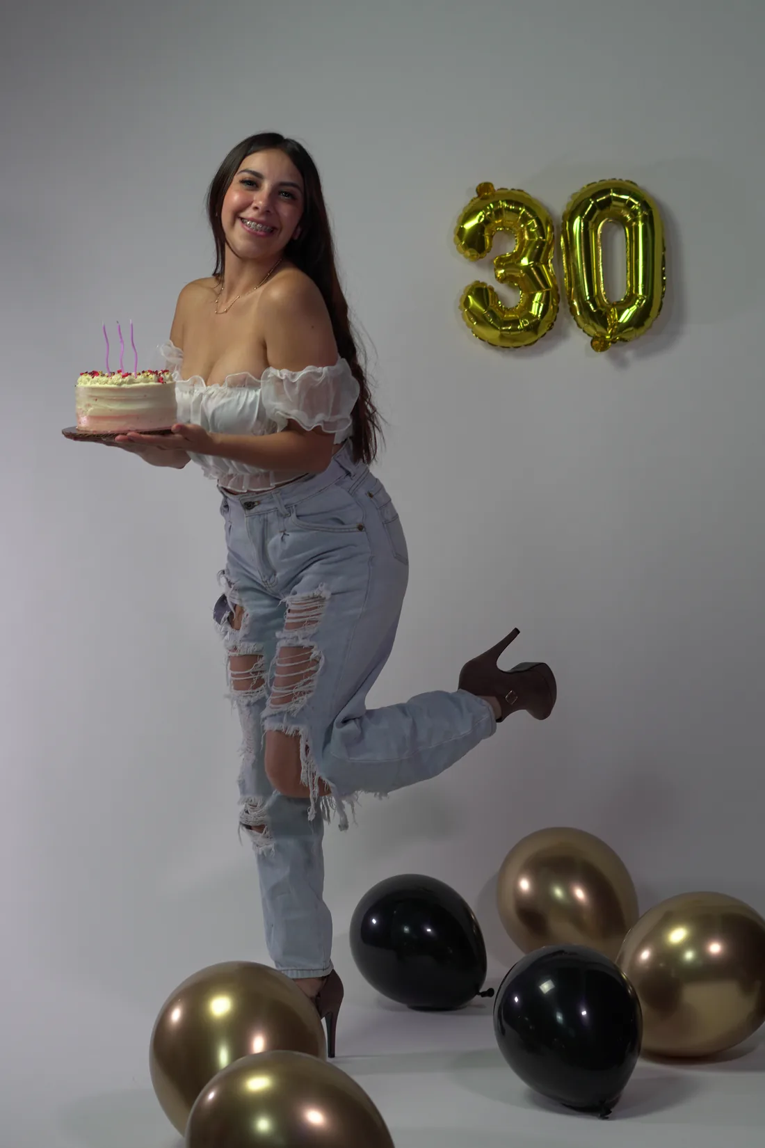 Sesión de fotos de cumpleaños en estudio con top blanco, jeans y globos dorados, toma 80